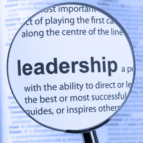 A magnifying glass hovered over the word 'Leadership' and its description in a dictionary.