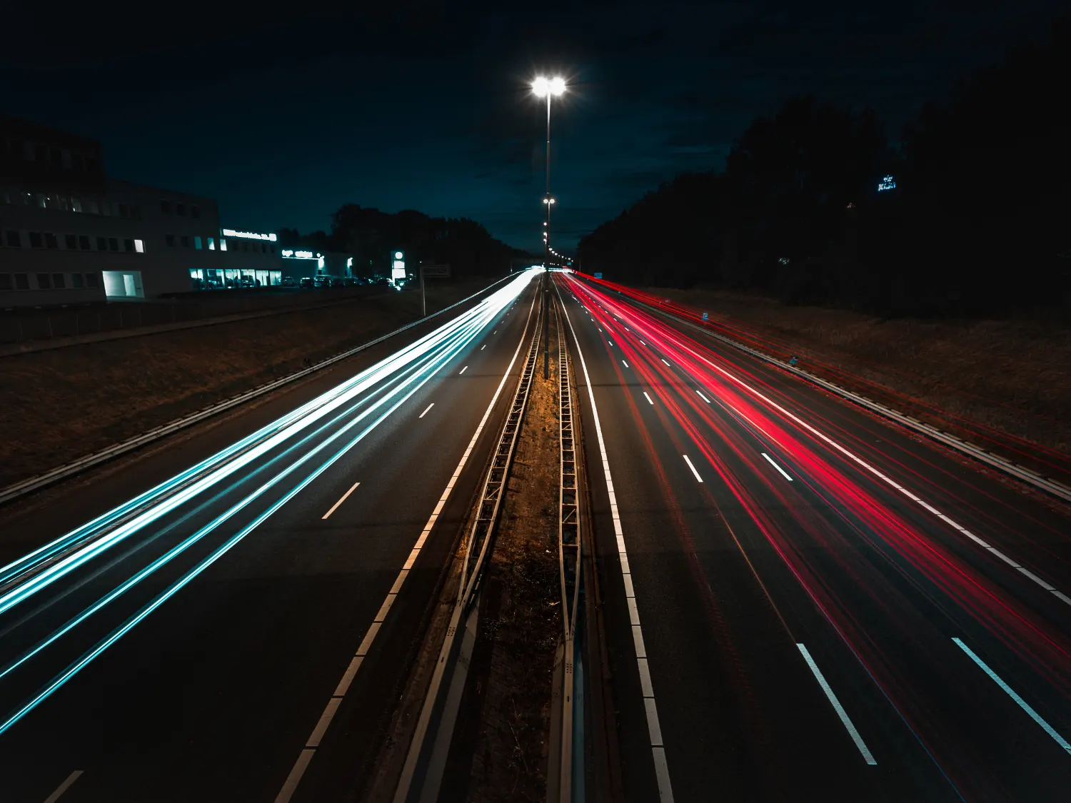 Fast cars leaving light-trails on a highway.